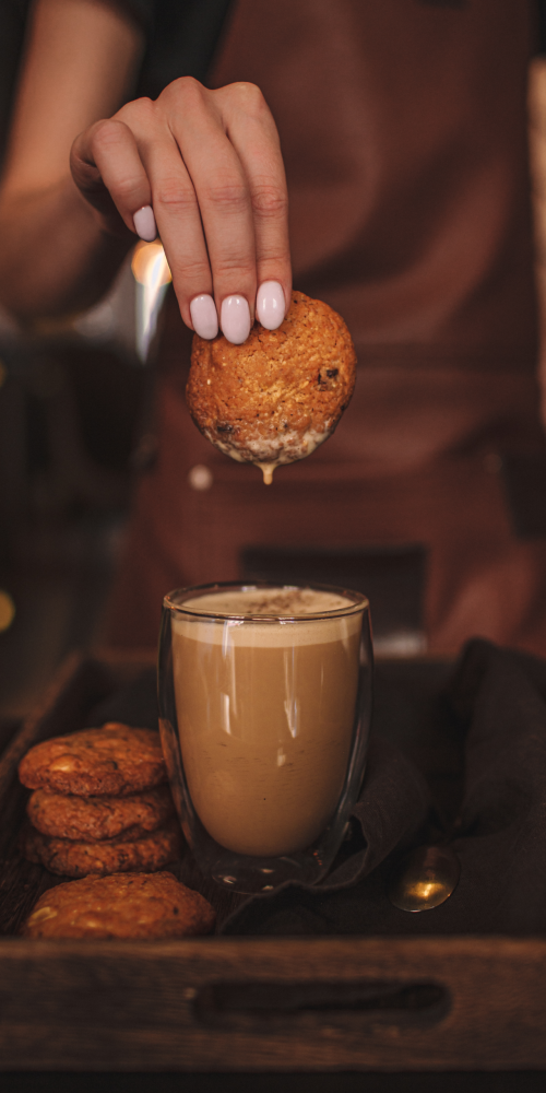 woman hand dipping cookie coffee